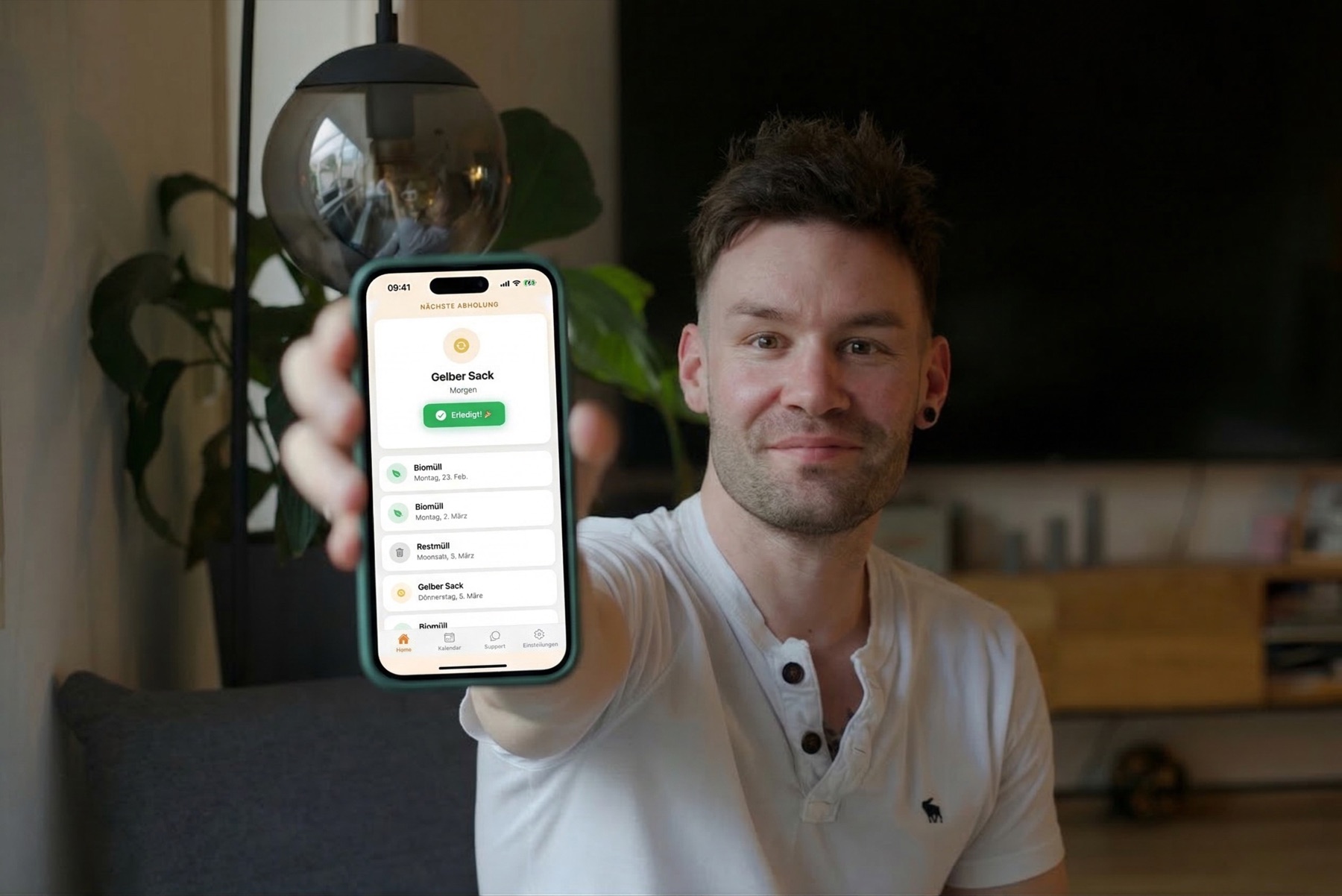 Timo Nisslbeck praesentiert eine entwickelte App auf einem Smartphone.
